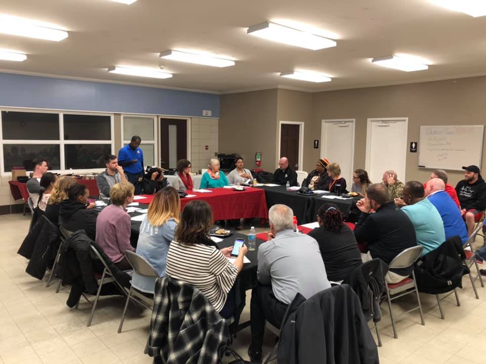 A group of people sitting around tables in a room.