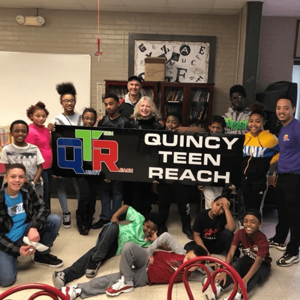 A group of people holding up signs in front of some bikes.