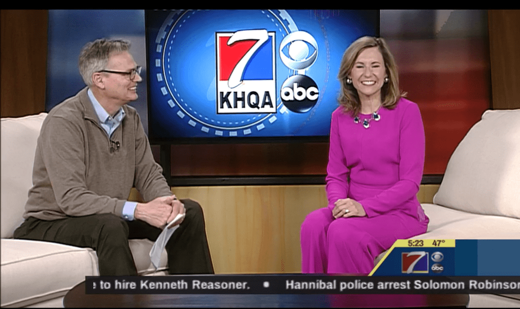 A man and woman sitting in front of a tv.