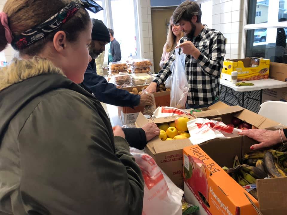 A group of people standing around boxes and bags.