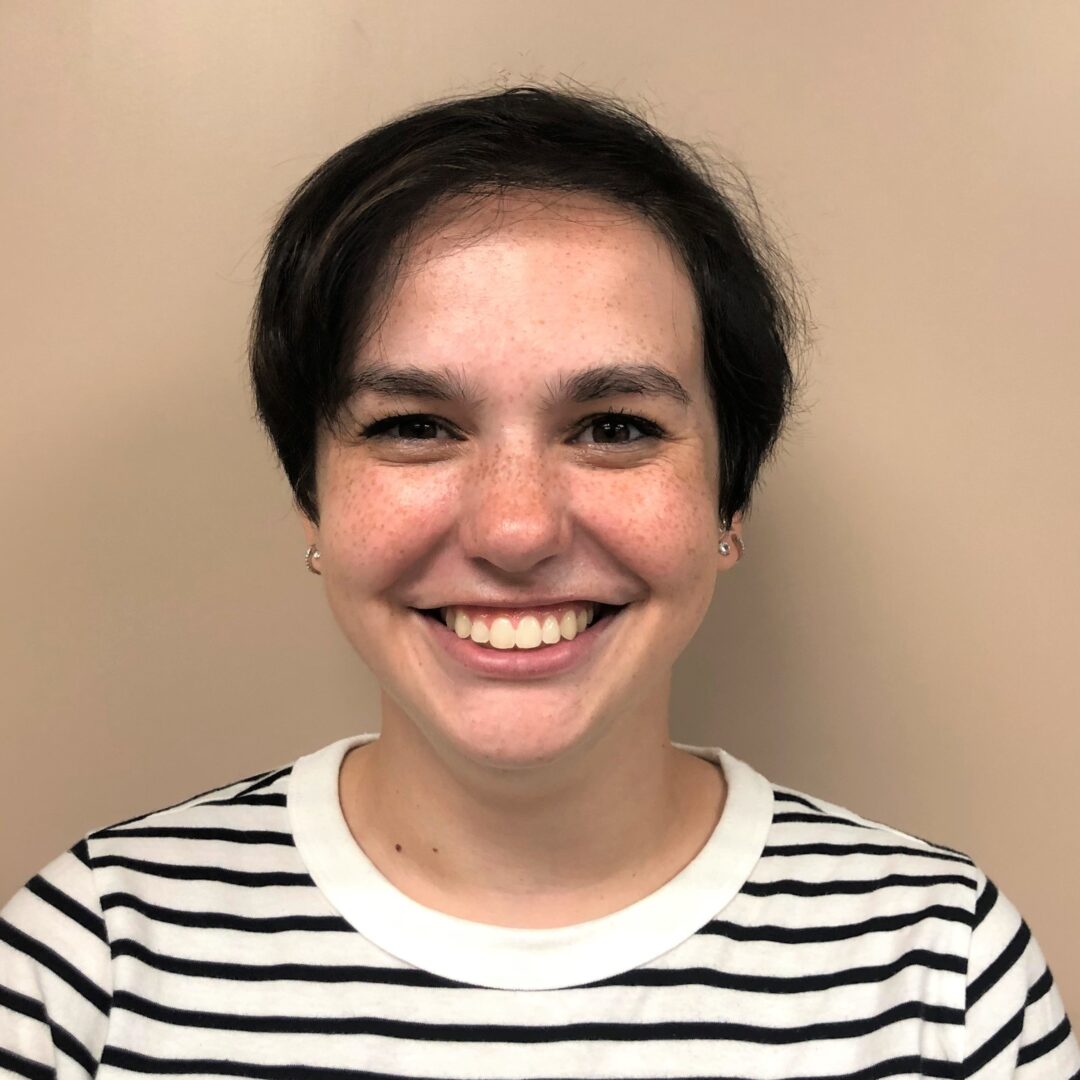 A woman with short hair smiles for the camera.